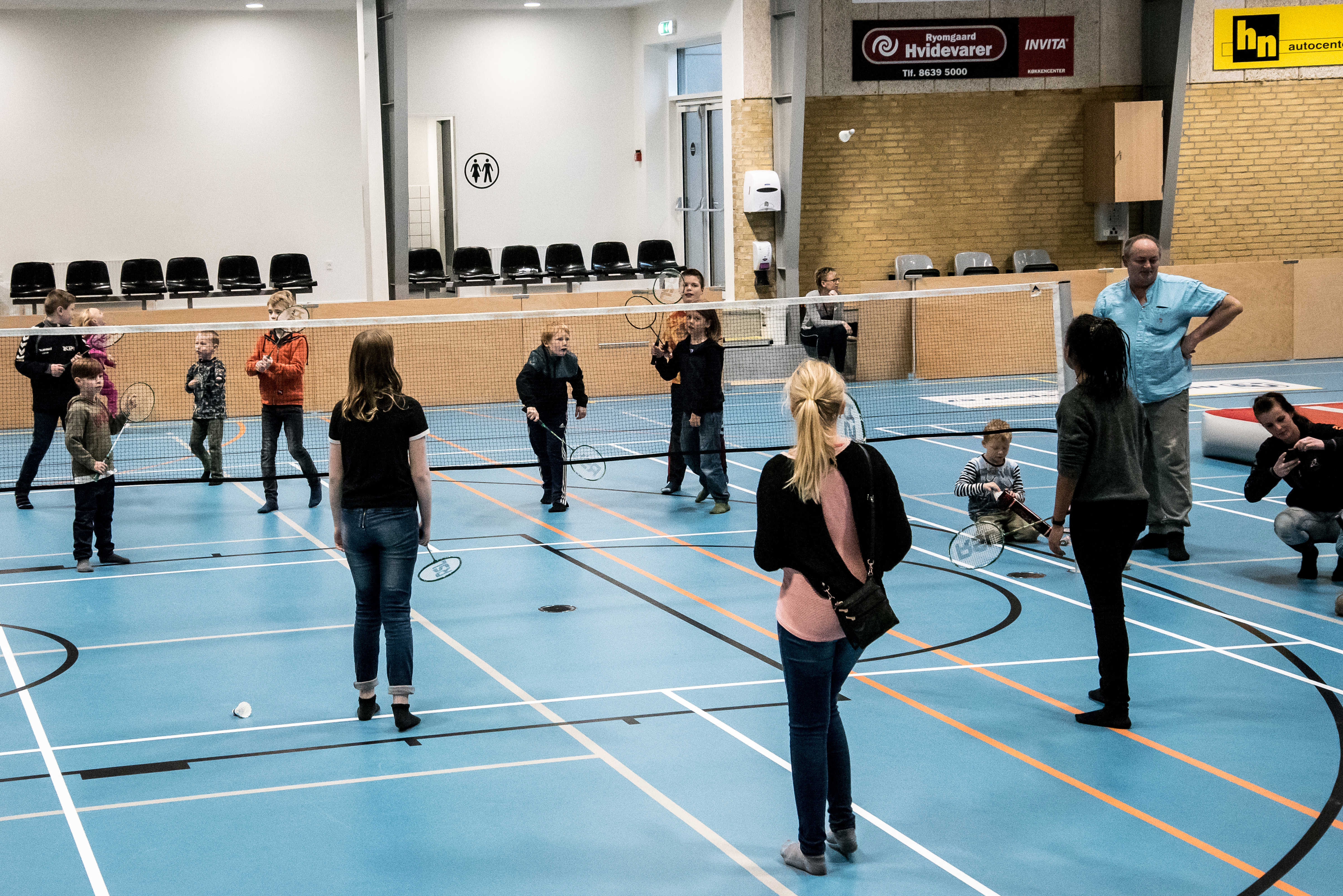 Børn der spiller badminton i hallen
